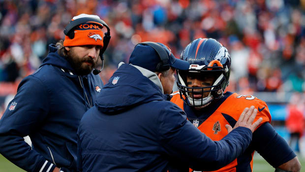 Denver Broncos head coach Sean Payton talks with quarterback Russell Wilson (3) and quarterbacks coach Davis Webb in the fourth quarter against the Kansas City Chiefs at Empower Field at Mile High.